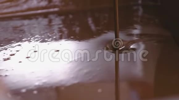 巧克力调质机中黑牛奶巧克力的喷浆特写镜头视频的预览图