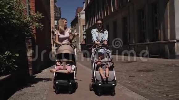 年轻快乐的母亲带着婴儿车的女人走在街上说话散步视频的预览图