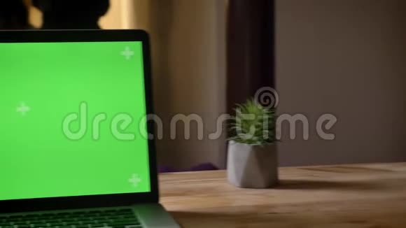 用相机拍摄笔记本电脑周围的特写镜头室内桌子上有绿色的彩色钥匙屏幕视频的预览图
