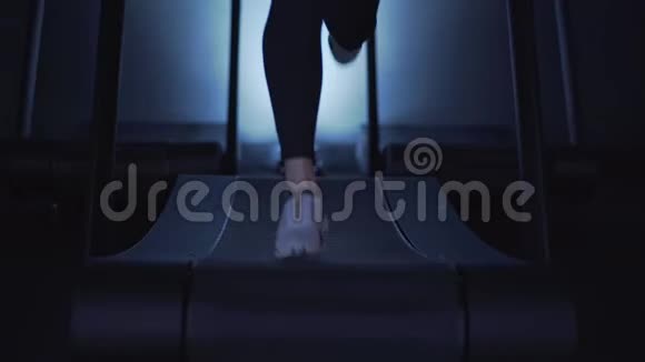 女士双腿穿着白色运动鞋在跑步机上慢动作视频的预览图