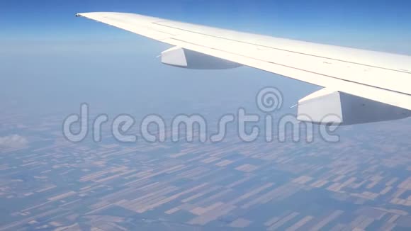 从飞机窗口观看飞机机翼在田野上方移动视频的预览图