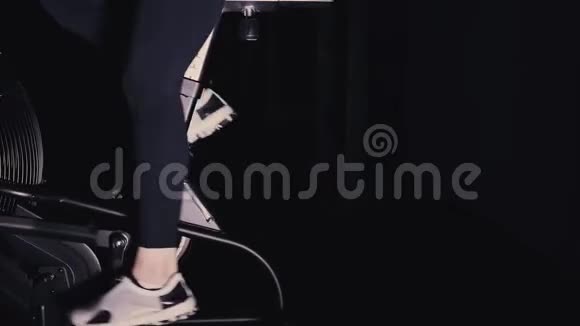 女人的双腿穿着白色运动鞋在健身房的自行车机上侧视平底锅视频的预览图