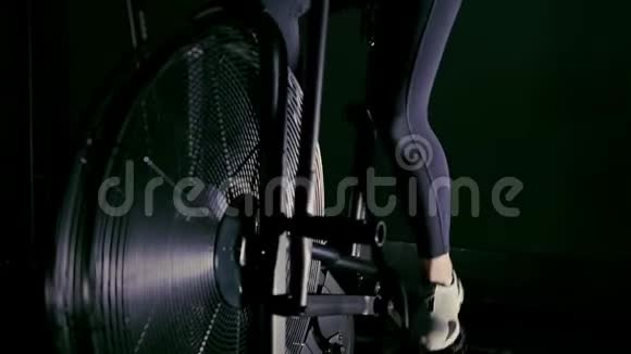 女人的腿穿着白色运动鞋在健身房的自行车机上视频的预览图