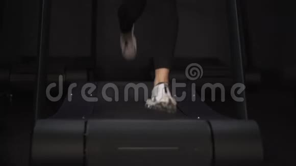 穿白色运动鞋在跑步机上慢跑的女人的腿视频的预览图