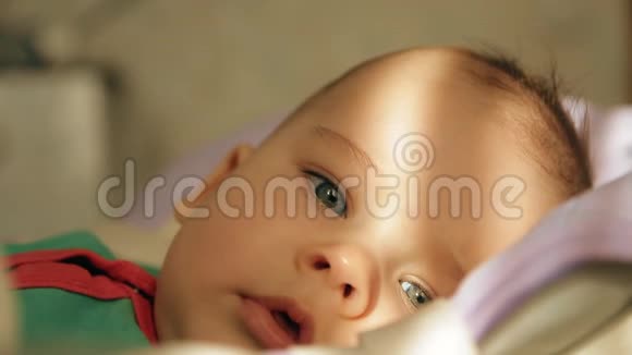一个快乐的婴儿躺在摇篮和微笑的特写镜头的肖像视频的预览图