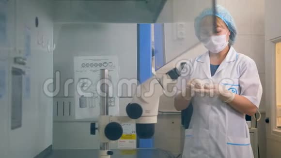 一位科学家在实验室用显微镜检验样品的特写镜头视频的预览图
