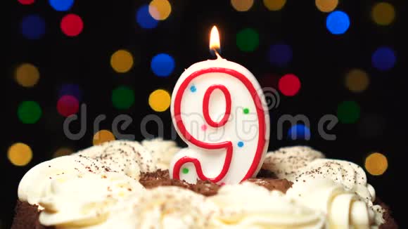 9号在蛋糕上面9号生日蜡烛燃烧在最后吹灭彩色模糊背景视频的预览图