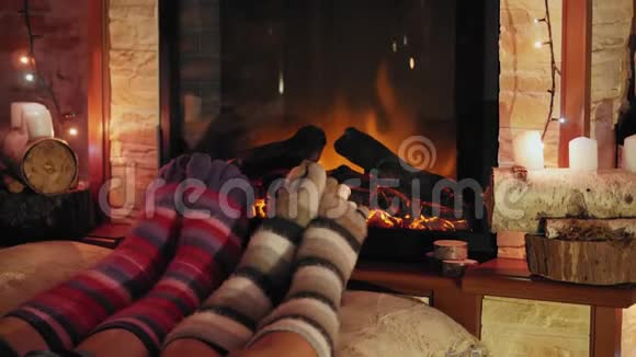 穿着羊毛袜的脚在燃烧的圣诞舒适壁炉旁视频的预览图