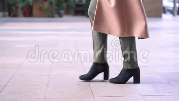 穿黑色靴子的女人在街上行走的腿视频的预览图