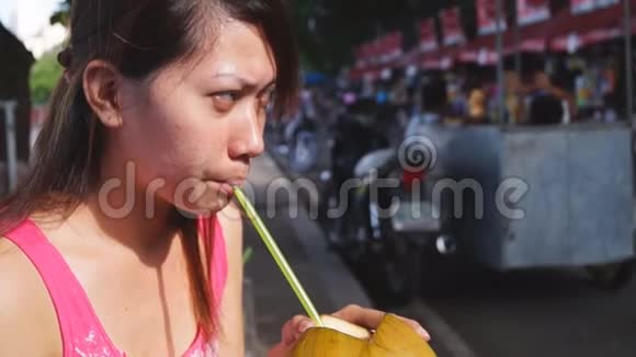 女士在湖边公园用吸管吸椰子汁视频的预览图