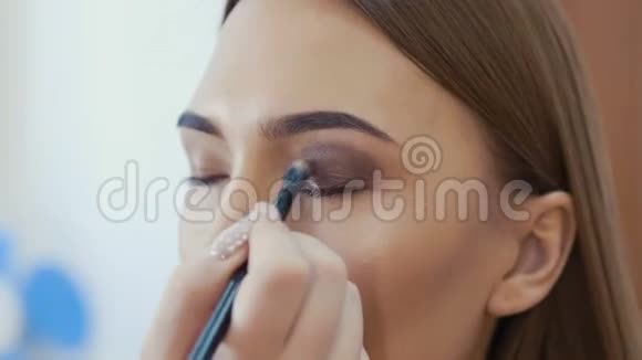 化妆师用眼影化妆来塑造的眼睛关闭视野烟熏的眼睛正确的看法视频的预览图