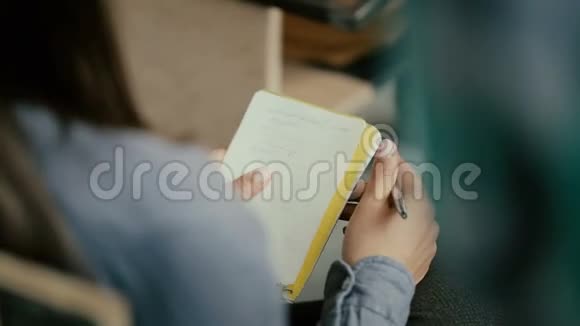 女性手的特写女人坐在椅子上写着笔记本学生在演讲时与人交谈视频的预览图