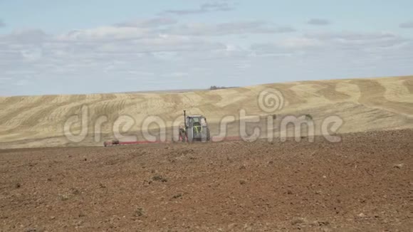 拖拉机在播种前用犁耕田耕地农业机械视频的预览图