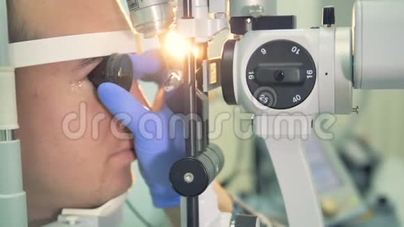一个眼镜师拿着一个镜片检查病人的眼睛背面视频的预览图