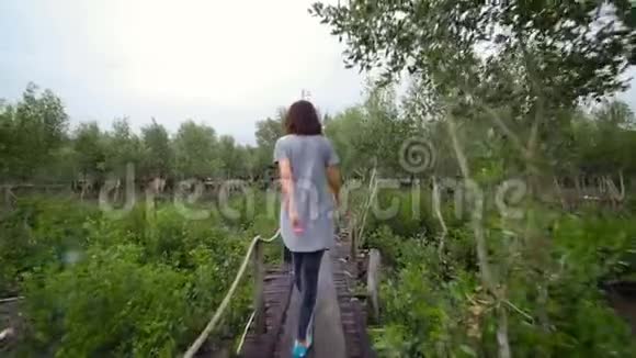 一个女孩在雨天走在木桥上视频的预览图