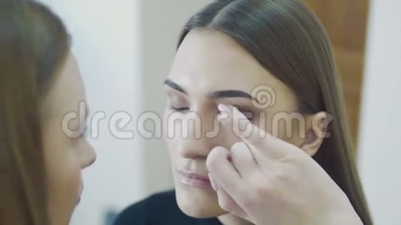 化妆师在模型上使用遮瑕膏s特写视频的预览图