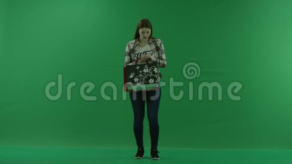 女孩检查绿色屏幕上袋子的内容视频的预览图