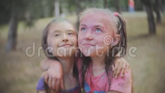 两个小女孩在夏天的公园里洒上彩色粉末视频的预览图