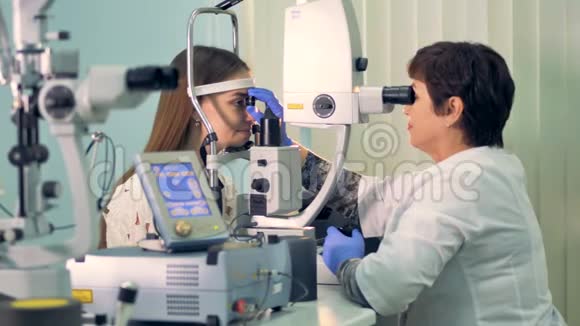 一位经验丰富的眼科医生检查妇女的眼睛视频的预览图