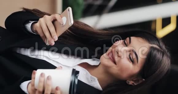垂直视频专业的年轻女商人站在城市街道上使用智能手机喝咖啡概念视频的预览图