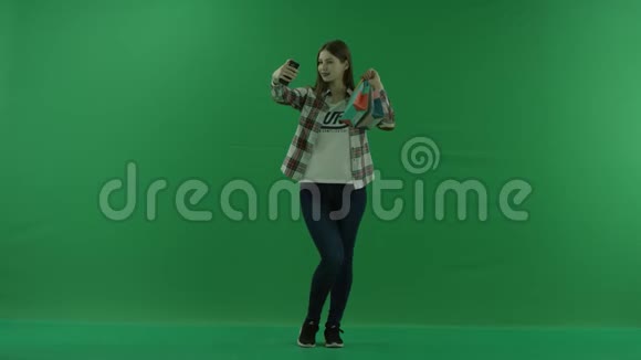 女孩女孩站着带着迷你包在绿色屏幕上自拍视频的预览图