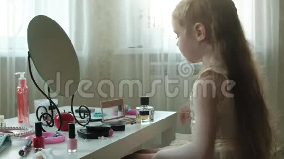 一个留着红色头发的小女孩洒上香水或马桶水照镜子化妆脸时尚风格视频的预览图