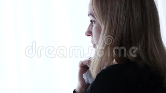 窗户附近沮丧的女人哭着想着什么4K视频的预览图