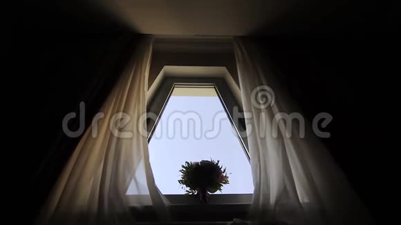窗户上有白色粉红色和红色的婚礼花束新娘早上窗户附近的气味视频的预览图