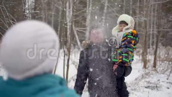 可爱的三口之家在雪地冬季公园玩得很开心父亲和儿子在冬天在外面玩投人视频的预览图