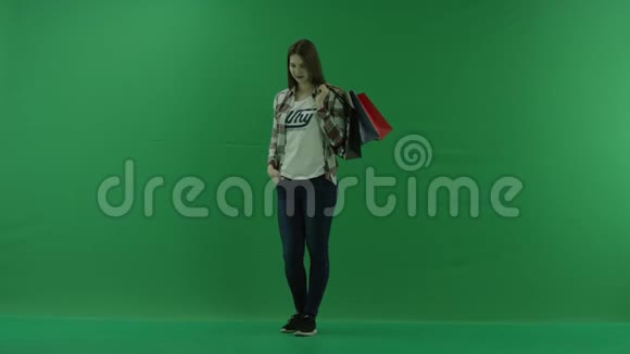 女孩的肩膀上放着购物袋站在半个转弯处左边绿色的屏幕上微笑着视频的预览图