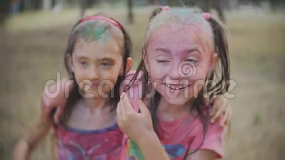 朋友们在两个兴奋的小女孩身上泼水上面涂着彩色粉末视频的预览图