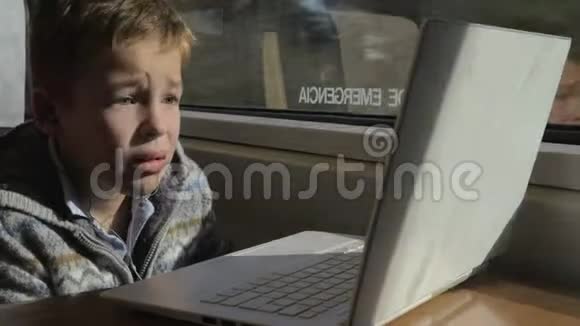 儿童乘坐火车在笔记本电脑上看电影视频的预览图