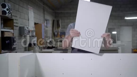 穿制服的成年男子在车库里用白色面板做支架视频的预览图