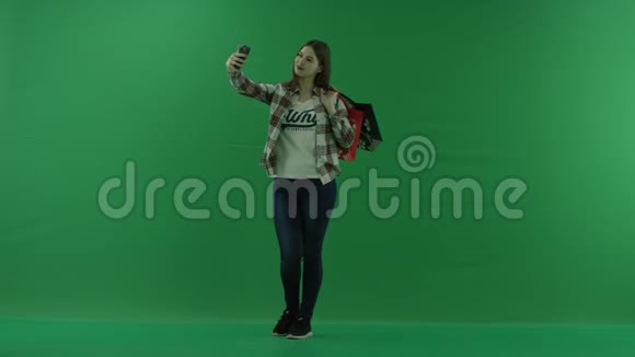 女孩肩膀上有购物袋站在半个转弯处向左看在绿色上自拍视频的预览图