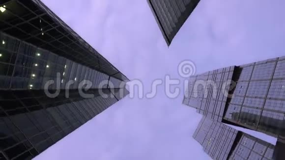 在现代摩天大楼前旋转的低角度镜头白天视频的预览图