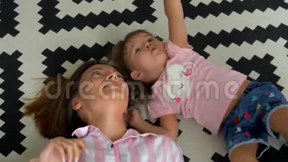 妈妈和女儿躺在地毯上出现视频的预览图