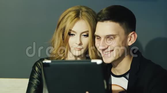 2025岁的年轻夫妇在咖啡馆里使用平板电脑视频的预览图