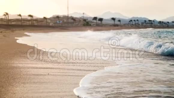 日落时分海浪在沙滩上翻滚这是一段美丽的慢镜头视频的预览图