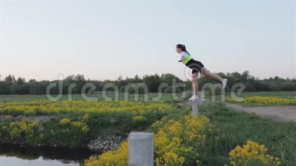 一个有目的的女人单腿站立并做瑜伽练习那女孩在日落时从事体育运动视频的预览图