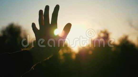 日落时分男人的手男人太阳下从车窗伸出的手慢动作视频的预览图
