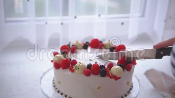 那个女人切了一块用浆果装饰的蛋糕视频的预览图