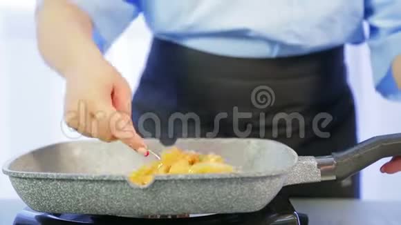 一个女人在平底锅里拌米粉时光飞逝视频的预览图