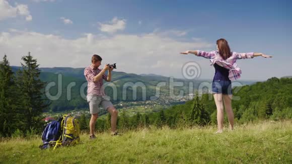 这家伙在山上背景的一个风景如画的地方给他的女朋友拍照附近是他们的视频的预览图