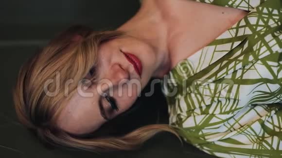 垂直视频一幅美丽的孕妇穿着绿色连衣裙在镜头里看和摆姿势的肖像慢动作视频的预览图
