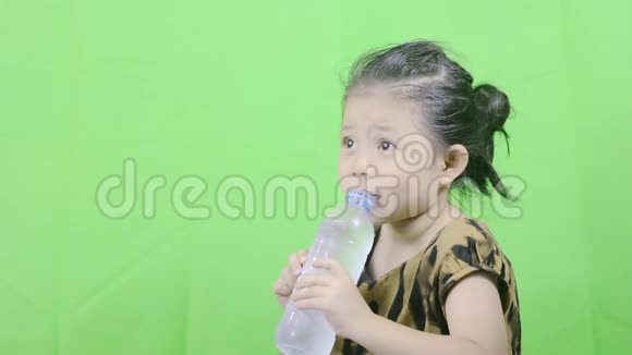 可爱的亚洲小女孩在一个清澈的瓶子里喝水视频的预览图