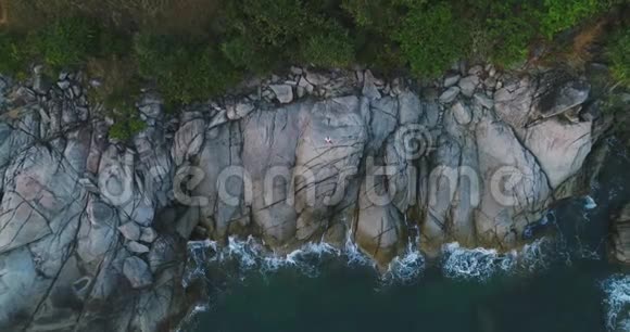 空中一个人独自站在靠近大海的悬崖上情绪化地摆姿势视频的预览图
