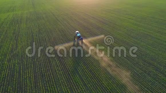 4K航空无人机镜头日落时分在大豆田里跟着拖拉机喷雾器视频的预览图