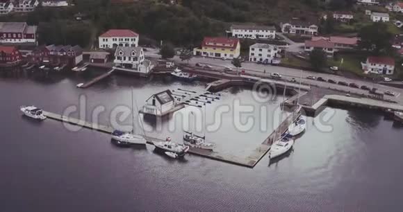 峡湾海岸有游艇木墩棚的空中村庄视频的预览图