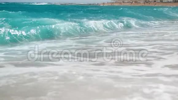 在阳光明媚的日子里金色沙滩上的蓝色海浪翻滚着4k慢镜头视频的预览图