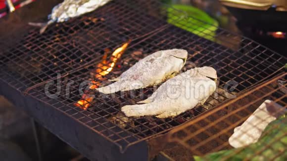 亚洲街头美食烤火煮的鱼传统菜肴游客和游客的海鲜夜食市场视频的预览图